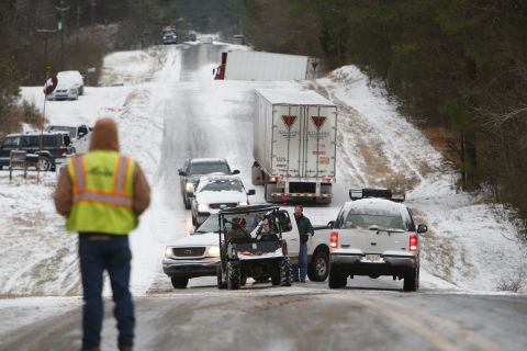 People work to clear stranded vehicles on County Road 25 in Wilsonville, Alabama, on Tuesday, January 28.