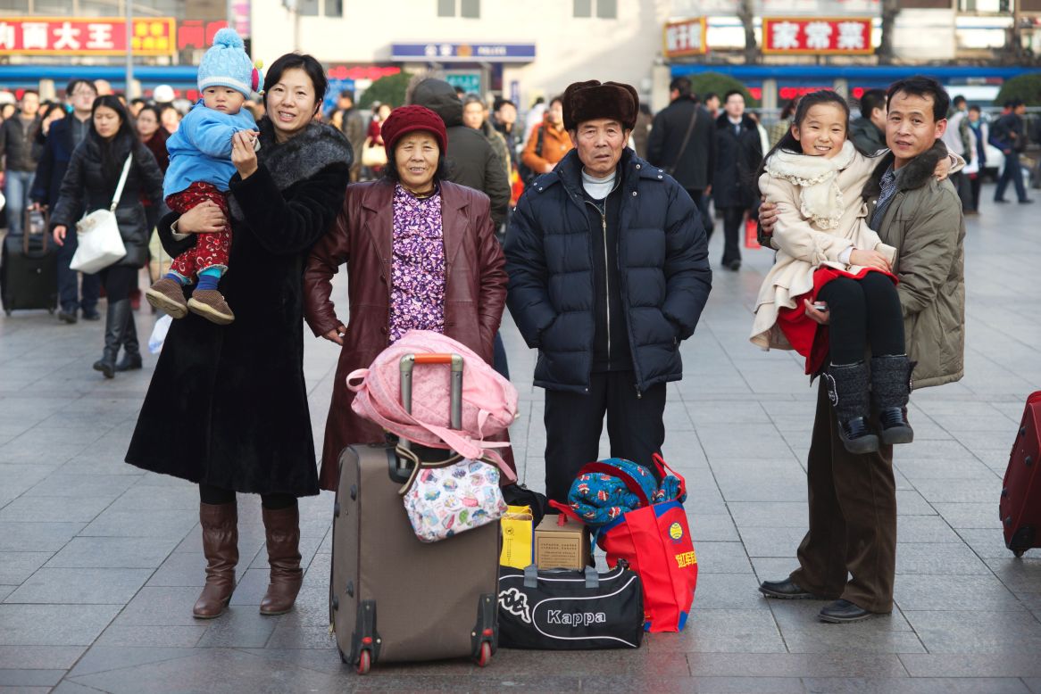 Li Canming (R) and Liu Shuxia (L) have lived in Beijing for 12 years. They're going back to Baotou, Inner Mongolia for Chinese New Year with their parents (center) and two children. The husband works in a factory making disposable tableware, while his wife does research for oilfields. Li is holding their 11-year-old daughter and Liu is holding their one-year-old son.