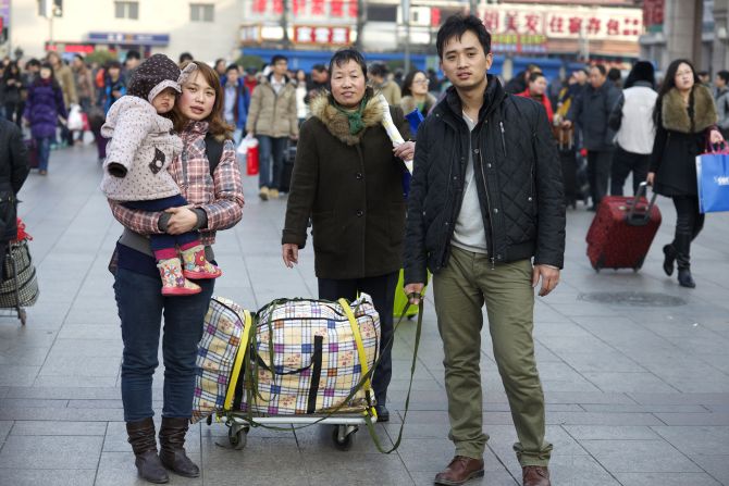 Cai Dongping (R) came to Beijing from Southern China's watery city of Shaoxing in Zhejiang province six years ago. He works in a factory assembling home electronic devices. Cai's wife is holding their three-year-old child and his mother accompanies them.