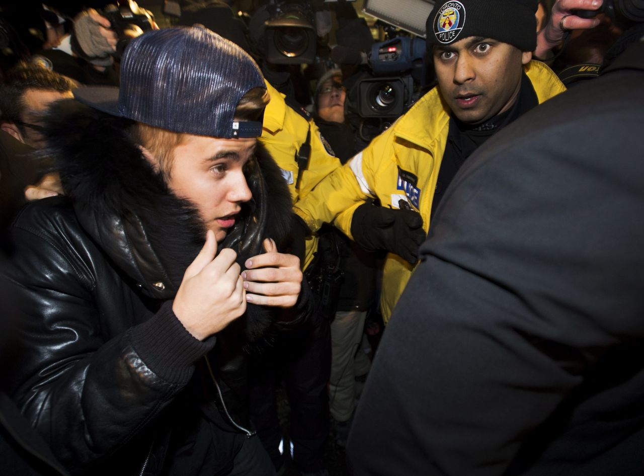 Justin Bieber, rodeado por reporteros, fans y policías, se entrega por un cargo de agresión en Toronto el miércoles 29 de enero.