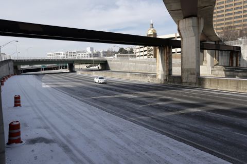 A lone car travels on Interstate 75/85 in downtown Atlanta on January 29, a day after the roadway was packed with vehicles.