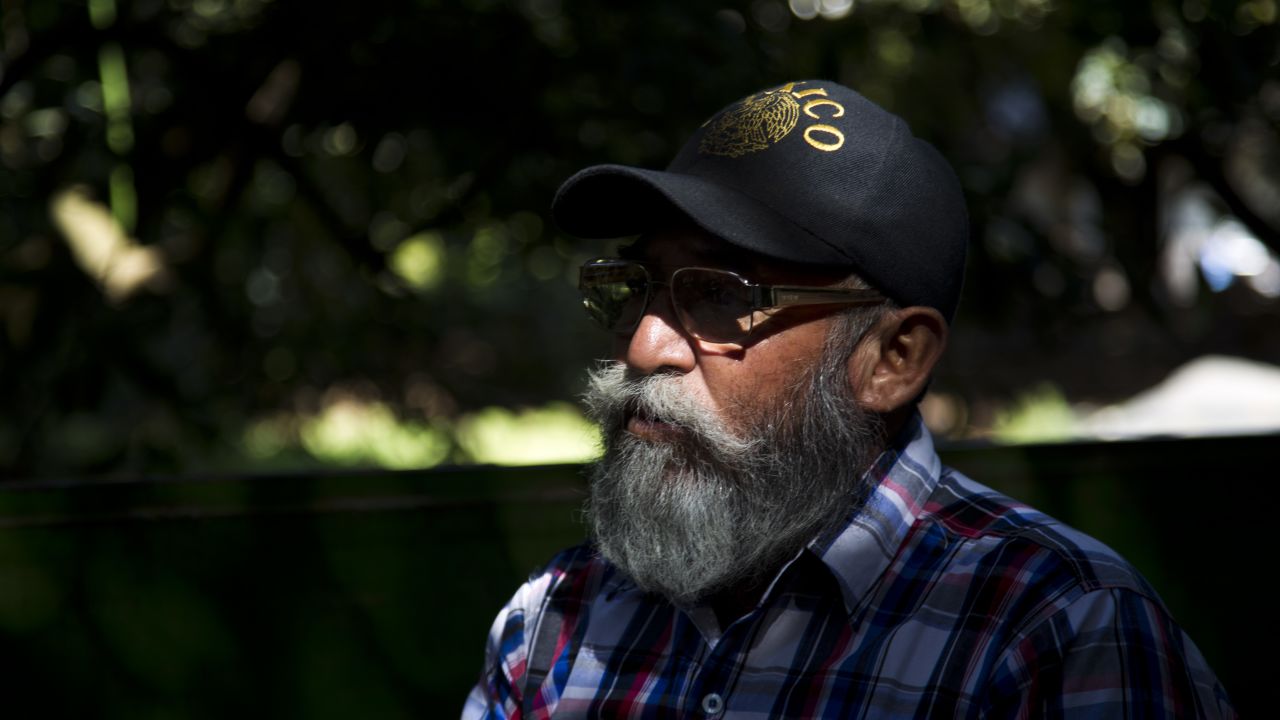 Estanislao Beltran aka 'papa piturfo' (Papa Smurf in English), leader of the Self-Protection Police, speaks at avocado orchard owned by the Ceballos family in the community of Tancitaro, state of Michoacan, Mexico, on January 16, 2014. The land is one of the several recovered by the Mexican vigilante militias battling drug-traffickers in the restive state of Michoacan, who on Thursday said they had returned several hundred acres of land seized from villagers by drug cartel members. A symbolic handover of some 654 acres (265 hectares) of land, which included many avocado and lemon orchards, took place in the village square of Tancitaro in the Michoacan highlands. AFP PHOTO/Hector Guerrero (Photo credit should read HECTOR GUERRERO/AFP/Getty Images)