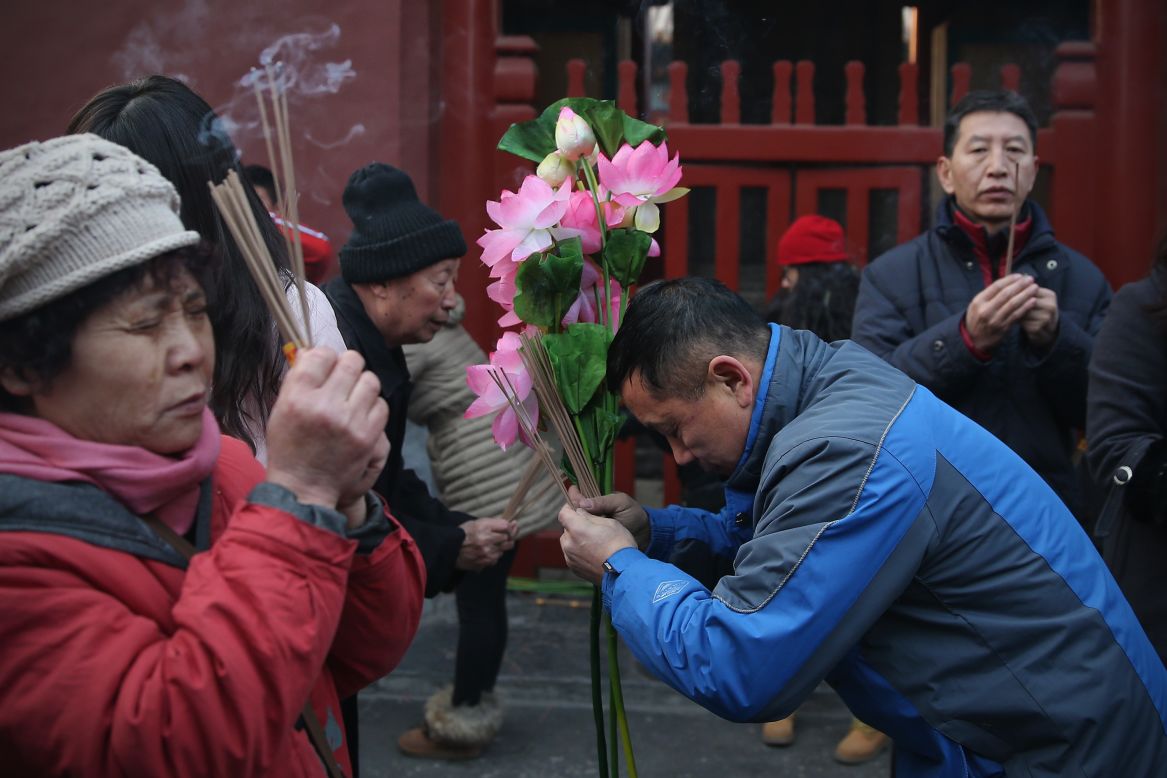 A crowd of people prays for good fortune outside the Yonghegong Lama Temple.
