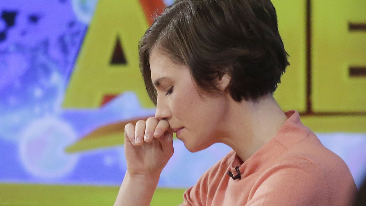 Amanda Knox puts her hand to her face while making a television appearance, Friday, Jan. 31, 2014 in New York. Knox said she will fight the reinstated guilty verdict against her and an ex-boyfriend in the 2007 slaying of a British roommate in Italy and vowed to "never go willingly" to face her fate in that country's judicial system . "I'm going to fight this to the very end," she said in an interview with Robin Roberts on ABC's "Good Morning America." (AP Photo/Mark Lennihan)