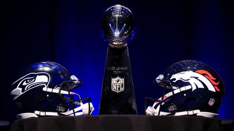 The Vince Lombardi Trophy is flanked by the helmets of the Seattle Seahawks and the Denver Broncos before the head coaches' news conference in New York on January 31.