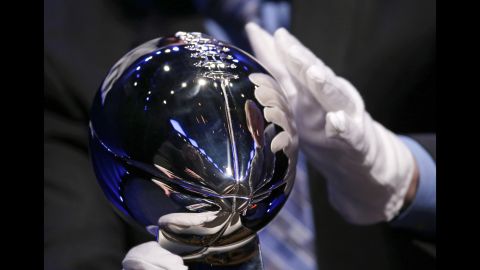 A man sets up the Lombardi Trophy for display before the head coaches' news conference.
