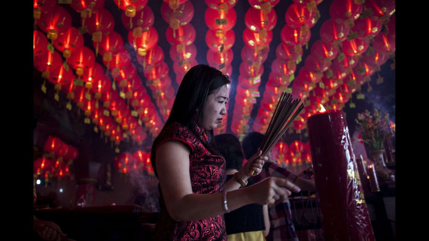 A woman holds incense sticks as she attends prayers at Bun San Bio Temple in Tangerang, Indonesia, on January 31.
