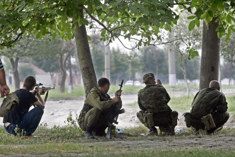 Ossetian soldiers take position near the school where a group of gunmen, wearing belts laden with explosives, held the hostages.