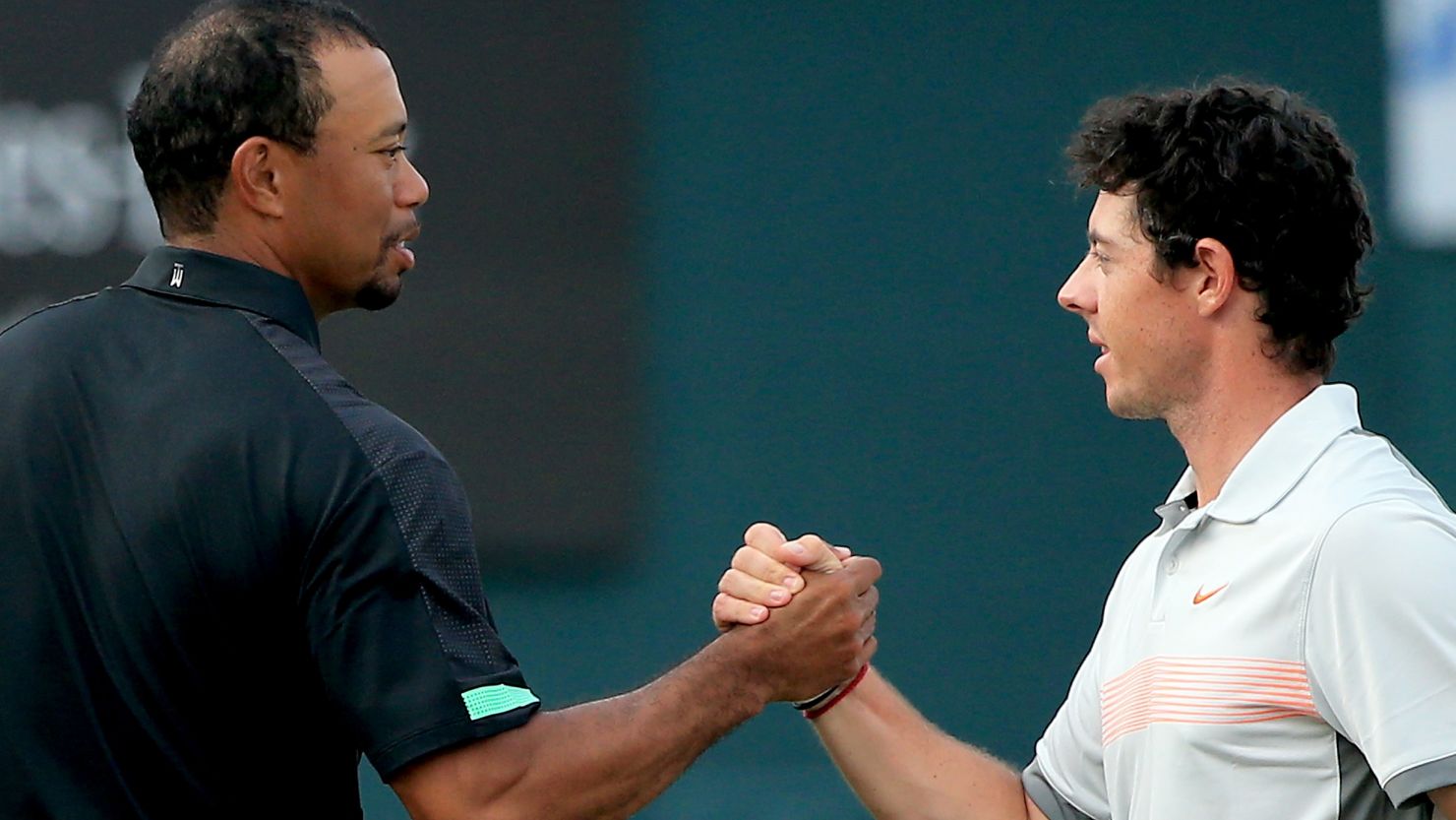 Rory McIlroy shakes hands with Tiger Woods after his second round 70 left him a shot clear of the field at the Dubai Desert Classic.