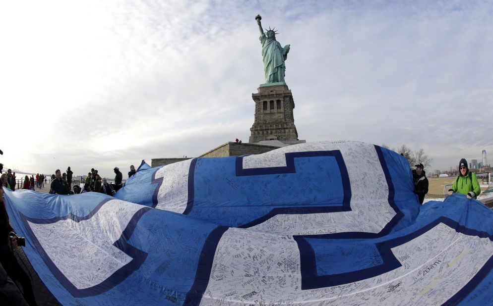 A giant Seahawks "12th Man" flag that flew on the Space Needle in Seattle before being signed by fans and brought to New York, is displayed at the Statue of Liberty on January 31. Sunday's game will be held in East Rutherford, New Jersey, just outside of New York City.