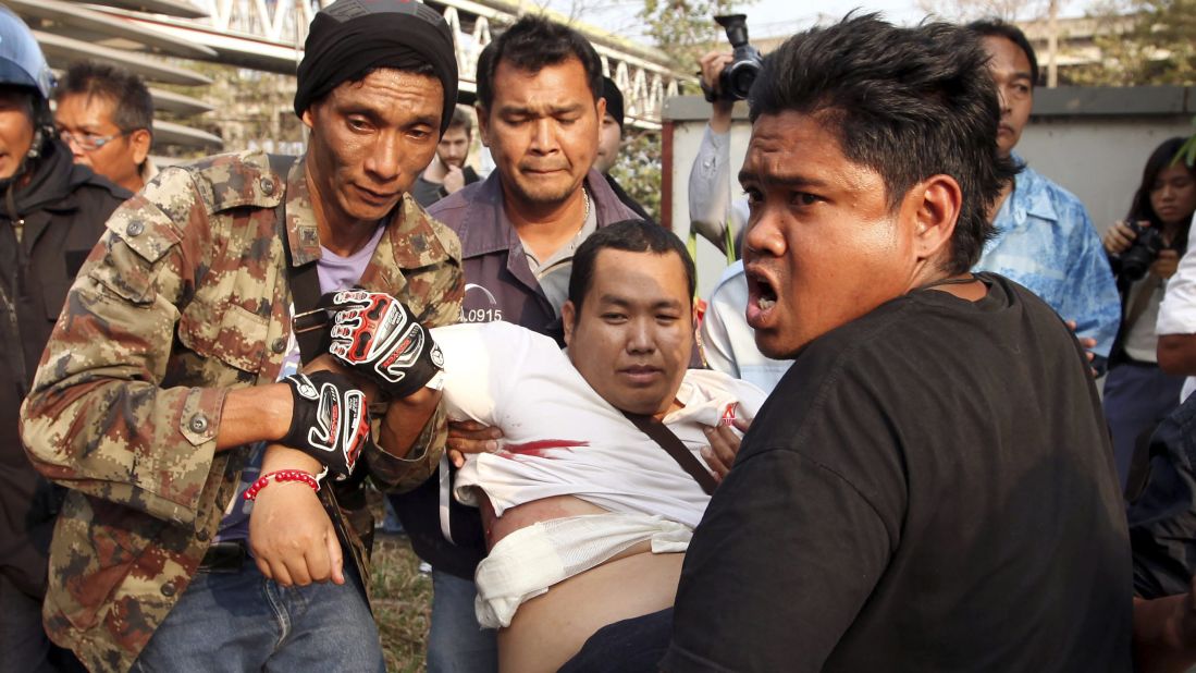 An injured government supporter is carried to a hospital during clashes with anti-government protesters in Bangkok on Saturday, February 1. Gunshots were fired during a confrontation, injuring at least six people. 