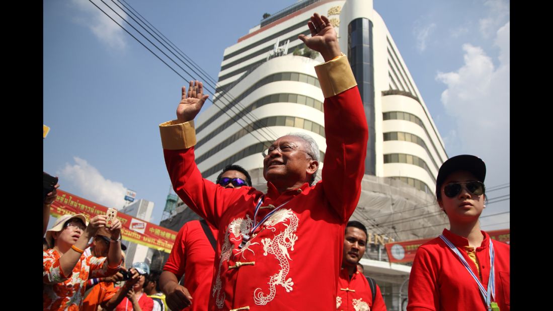Anti-government protest leader Suthep Thaugsuban cheers during a march through Bangkok's Chinatown. 