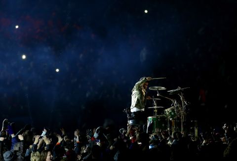 Fans surround Mars as he performs a drum solo to start the show.