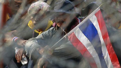 Protesters stake out positions behind barbed wire during a rally in Bangkok on February 3.