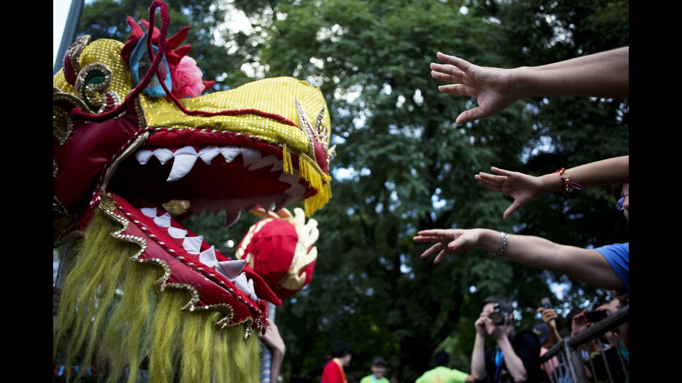 People try to touch a dragon puppet during a parade in Buenos Aires on Saturday, February 1.