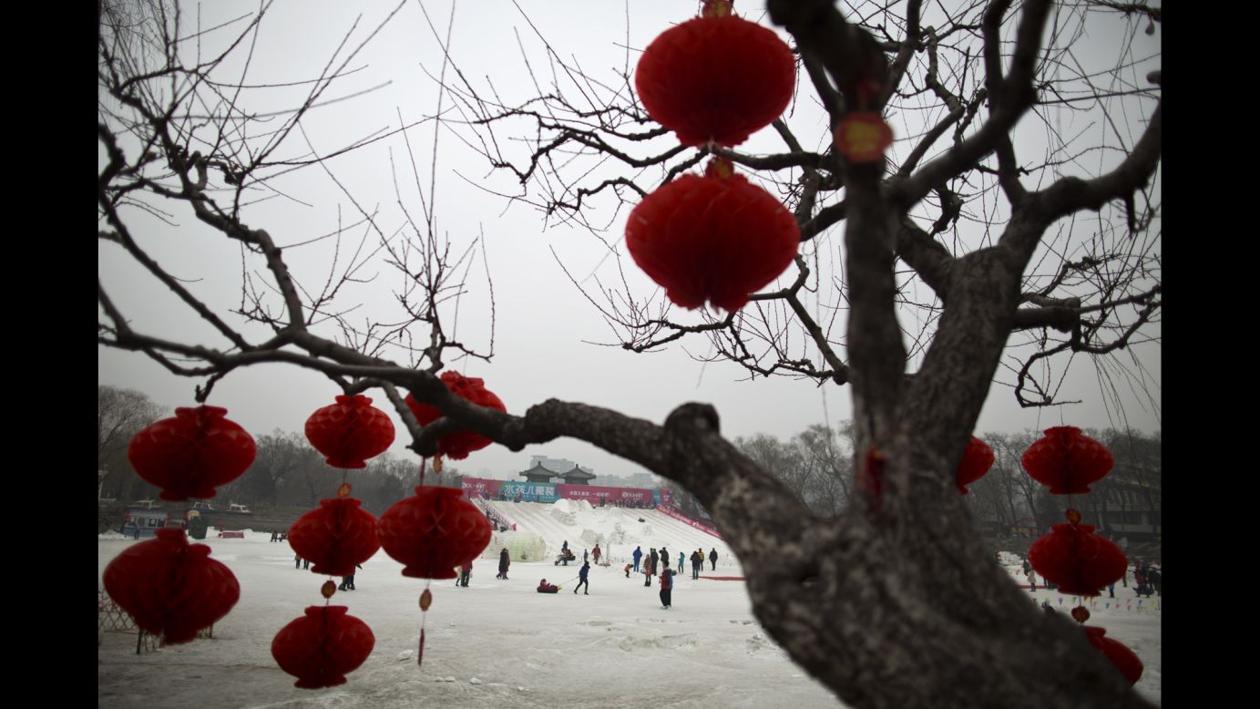 People play on an iced lake covered with artificial snow at Longtan Park in Beijing on February 1.