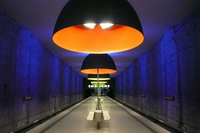 Enormes domos de luz, bañando la plataforma en tonos evocadores de azul, rojo y amarillo, hacen que esta estación, de lo contrario ordinaria, sobresalga.