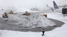 Plows clear runways as snow falls at Newark Liberty International Airport Monday, Feb. 3, 2014, in Newark, N.J. Air traffic is disrupted in Ohio, the Mid-Atlantic and the Northeast as another winter storm bears down on the eastern U.S., only a day after temperatures soared into the 50s. (AP Photo/Kiichiro Sato)