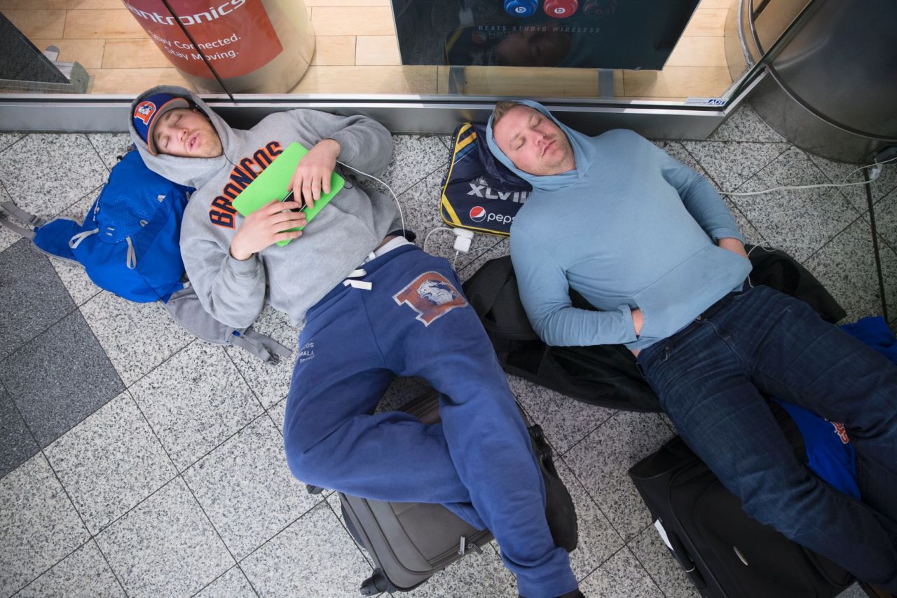 Drew Brown, left, and Matt Robbins sleep on the floor at LaGuardia Airport on February 3 after heavy snow in New York affected their flight. The winter storm stranded thousands of fans trying to head home after the Super Bowl.