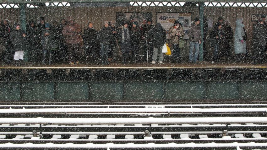 Commuters wait for a train as snow falls in New York on February 3.