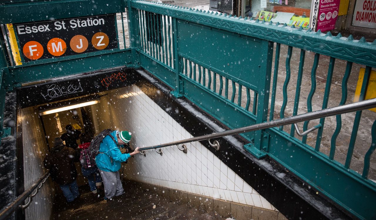 A man uses the handrail to get into a subway station February 3 on New York's Lower East Side.