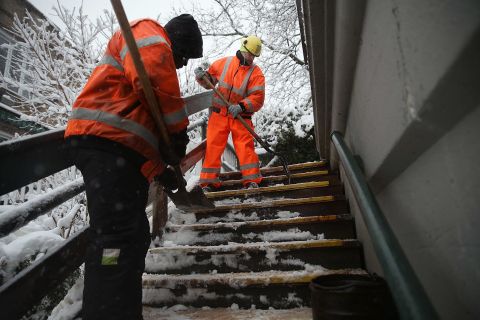 City workers clear snow and ice from stairs in Brooklyn on February 3.
