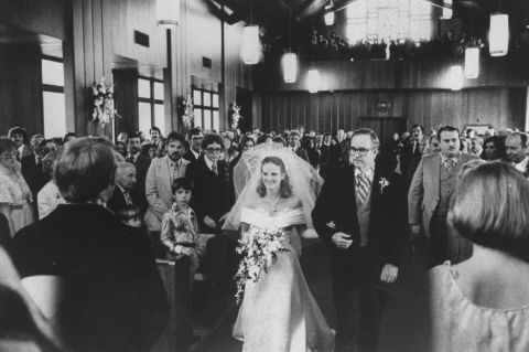 Hearst is walked down the aisle by her father, Randolph Hearst, at the Navy chapel at her wedding to Bernard Shaw in April 1979. 