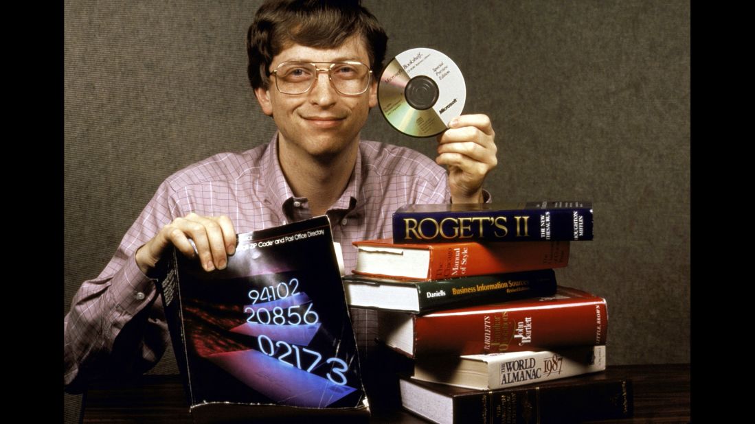 Gates holds up Bookshelf, a new compact disc for computers which holds all the information contained in the books pictured. 