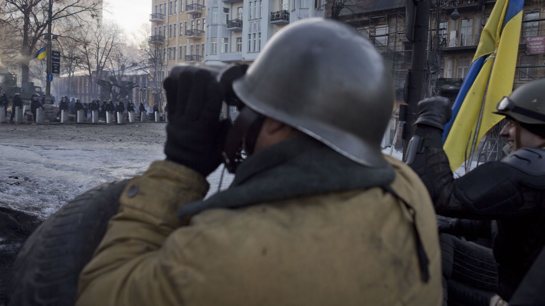 Protesters keep an eye on police February 4 as they man a barricade in Kiev.