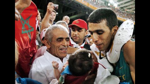 Moroccan runner Hicham El Guerrouj, right, smiles at his baby daughter, Hiba, next to his father, El Ayachi, at the 2004 Olympic Games in Greece.