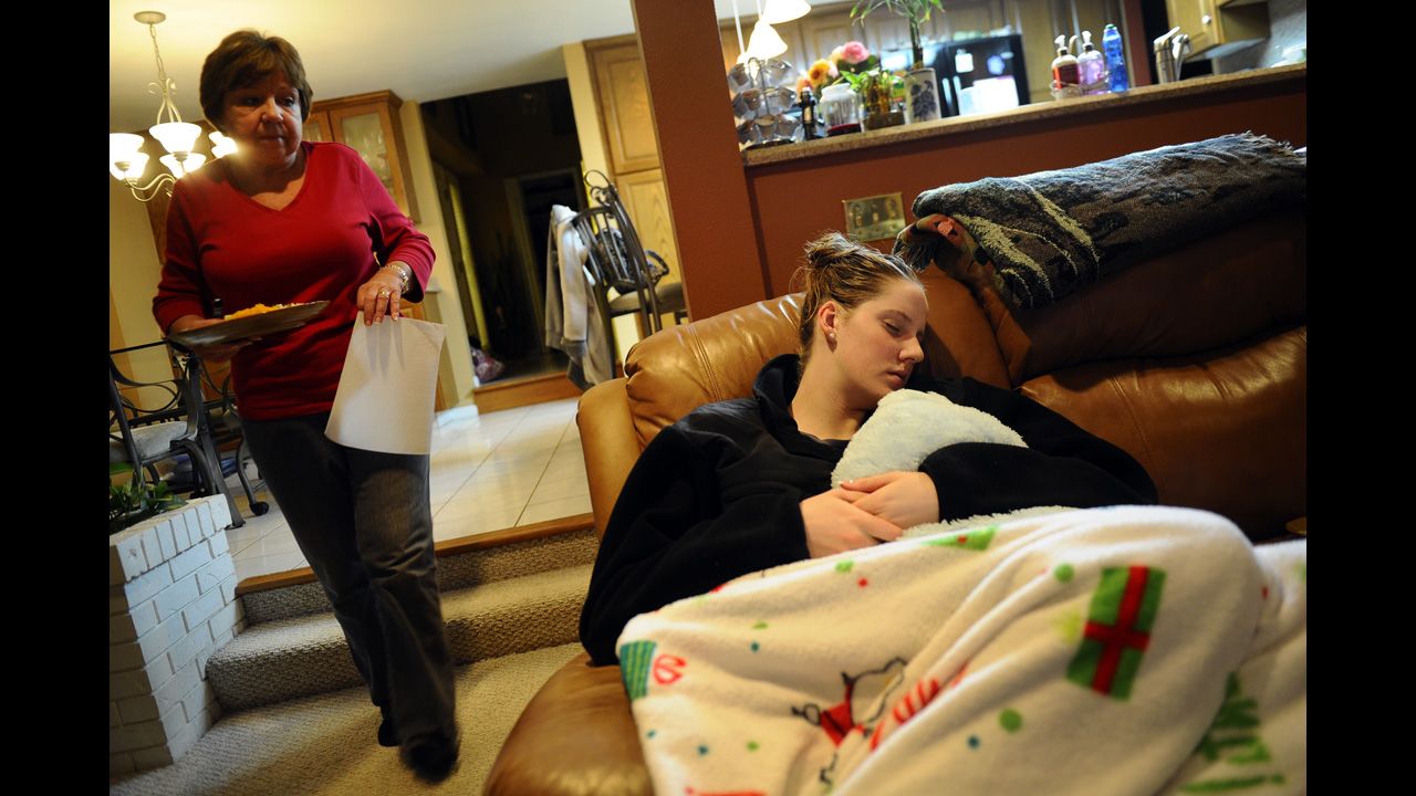 U.S. swimmer Missy Franklin falls asleep on the sofa while her mother, D.A., prepares dinner at their home in Colorado in 2011.
