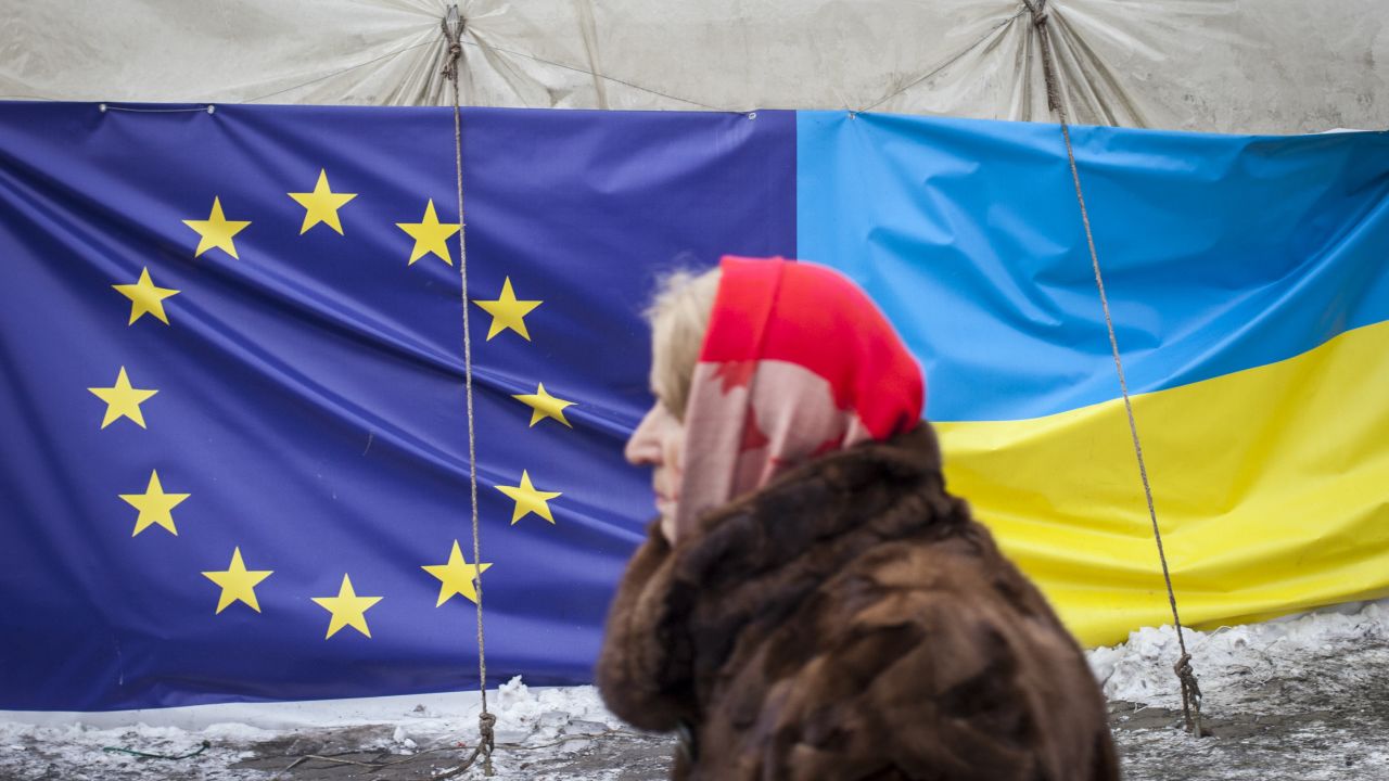 A woman walks past a tent displaying the European Union and Ukrainian flags in Independence Square on January 28, 2014 in Kiev, Ukraine.