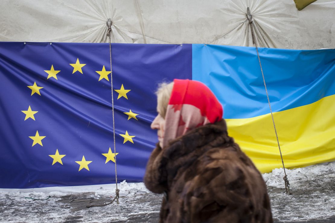 A woman walks past a tent displaying the European Union and Ukrainian flags in Independence Square on January 28, 2014 in Kiev, Ukraine. 