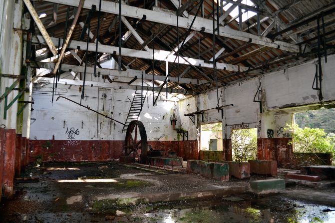 Inside the building was a large, rusty steel wheel and walls painted in a red and white horizon line paint scheme. 