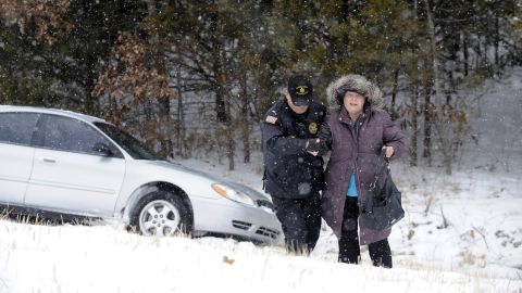 Lt. Rick Lucy of the Baxter County Sheriff's Office helps Donna Mullaney up an embankment in Mountain Home, Arkansas, after she lost control of her vehicle on an icy road February 4.