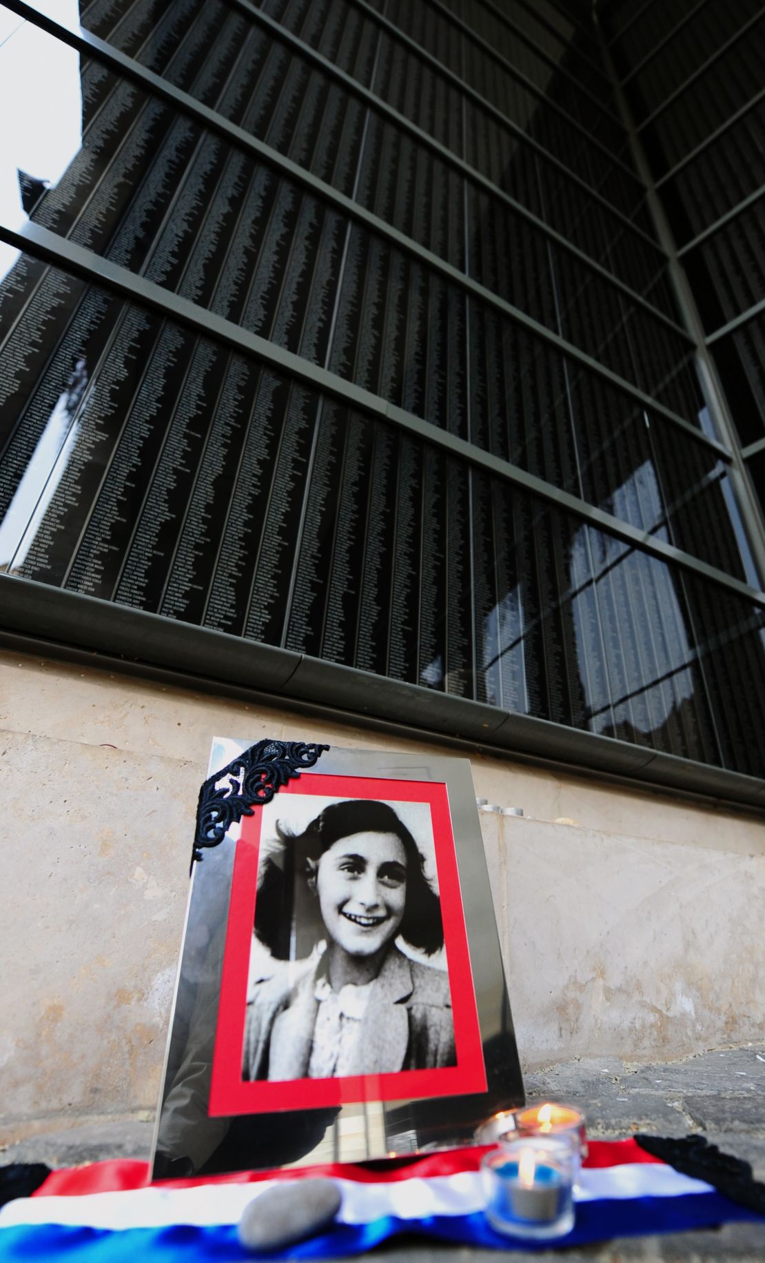 A portrait of Anne Frank stands in front of the memorial of Central Europe's first Holocaust museum in Budapest.