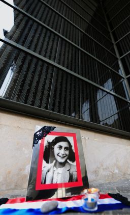 A portrait of Anne Frank stands in front of a black marble wall with the names of the Hungarian holocaust victims at the memorial of Central Europe's first Holocaust museum in Budapest on January 27, 2014.
