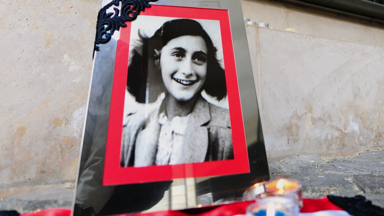 A portrait of Anne Frank stands in front of a black marble wall with the names of the Hungarian holocaust victims at the memorial of Central Europe's first Holocaust museum in Budapest on January 27, 2014.