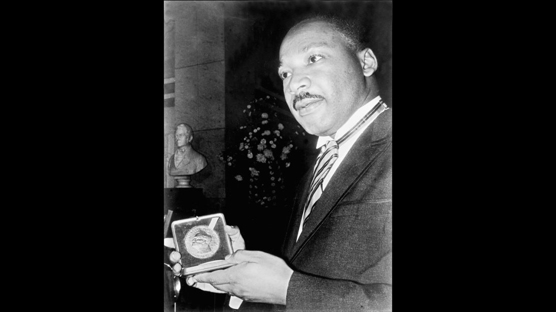 Caption:	 US clergyman and leader of the Movement against Racial Segregation Martin Luther King, displays 10 December 1964 in Oslo his Nobel Peace Prize medal. The only black man whose birthday is a national holiday, Martin Luther King was the leader of the moral fight against racism in America wen he was fatally shot by James Earl Ray 04 April 1968 at the age of 39. (Photo credit should read -/AFP/Getty Images)