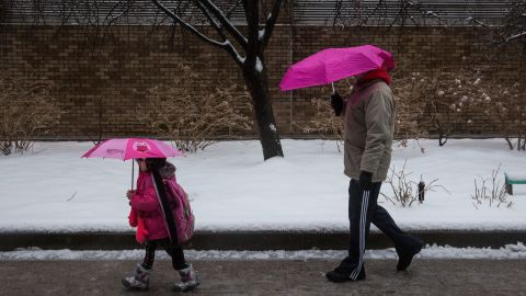 A man and a girl walk down a street February 5 in the Greenwich Village neighborhood of New York City.