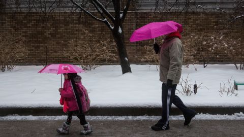 A man and a girl walk down a street February 5 in the Greenwich Village neighborhood of New York City.