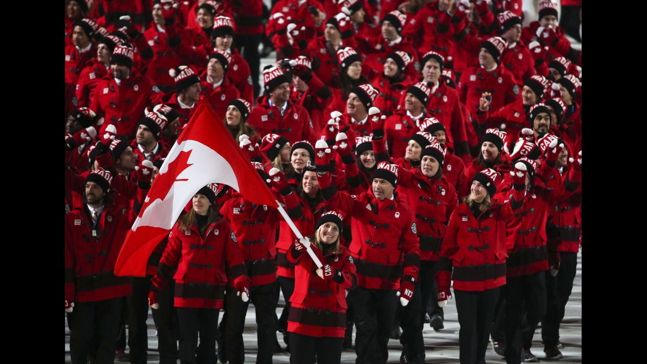 The Canadians, led by hockey player Hayley Wickenheiser, enter the stadium.