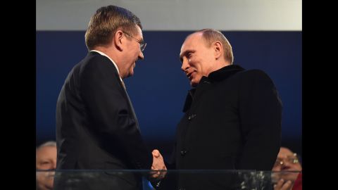 Thomas Bach, president of the International Olympic Committee, shakes hands with Russian President Vladimir Putin, right.