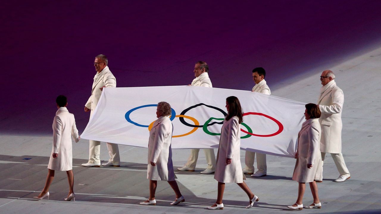 Olympic flag bearers carry the flag onto the floor during the opening ceremony.