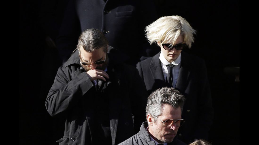 Actor Joaquin Phoenix, left, exits the church. Phoenix appeared with Hoffman in "The Master."
