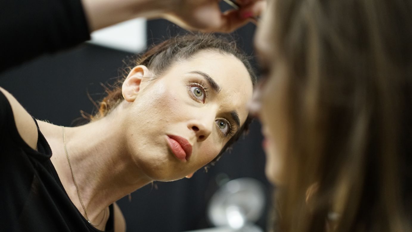 A makeup artist touches up a model before the Tadashi Shoji show.