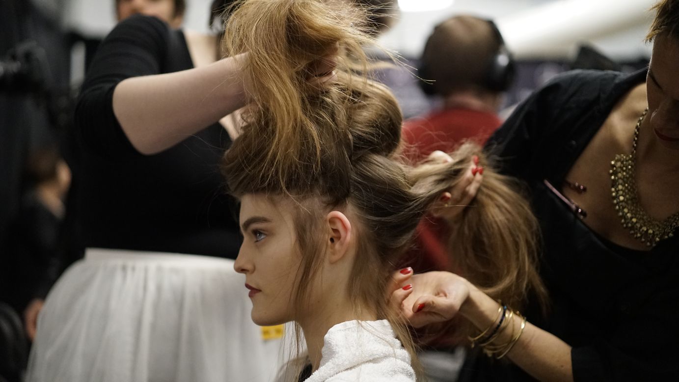 A model's hair gets pulled every which way to create a loosely braided updo for Tadashi Shoji's show.