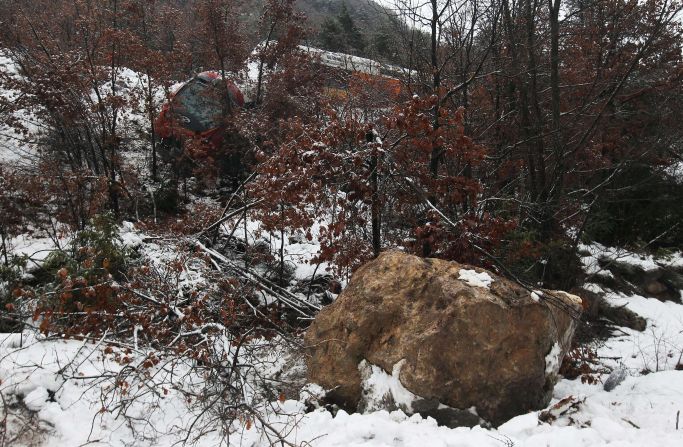 The boulder that caused the derailment sits below the damaged train. 