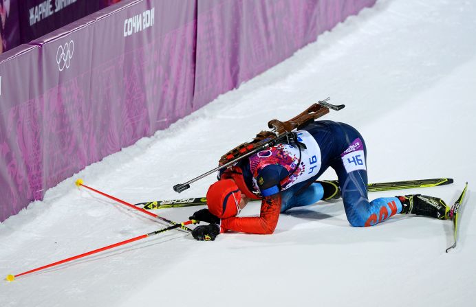 Dmitry Malyshko of Russia collapses in the snow after competing in the 10-kilometer biathlon sprint.