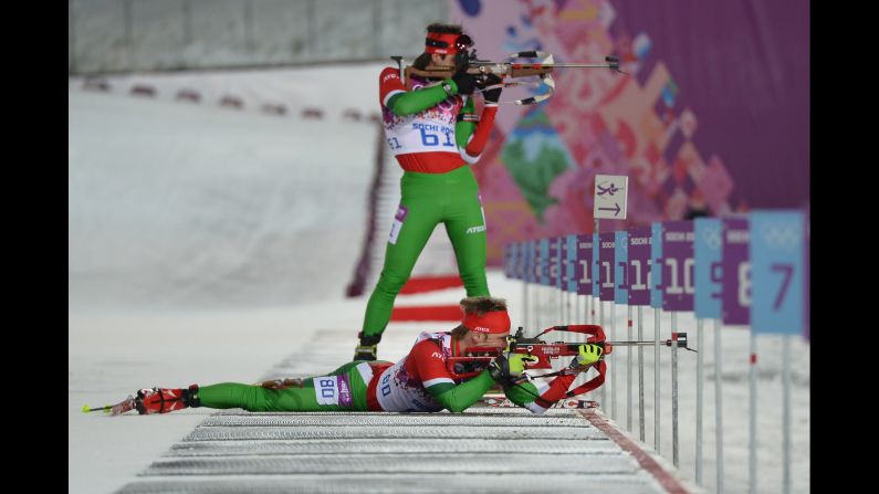 Belarussian biathletes Evgeny Abramenko, standing, and Yuryi Liadov shoot during the men's 10-kilometer sprint on February 8.